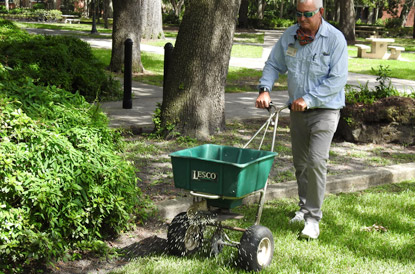 photo of a man pushing a yard fertilizer